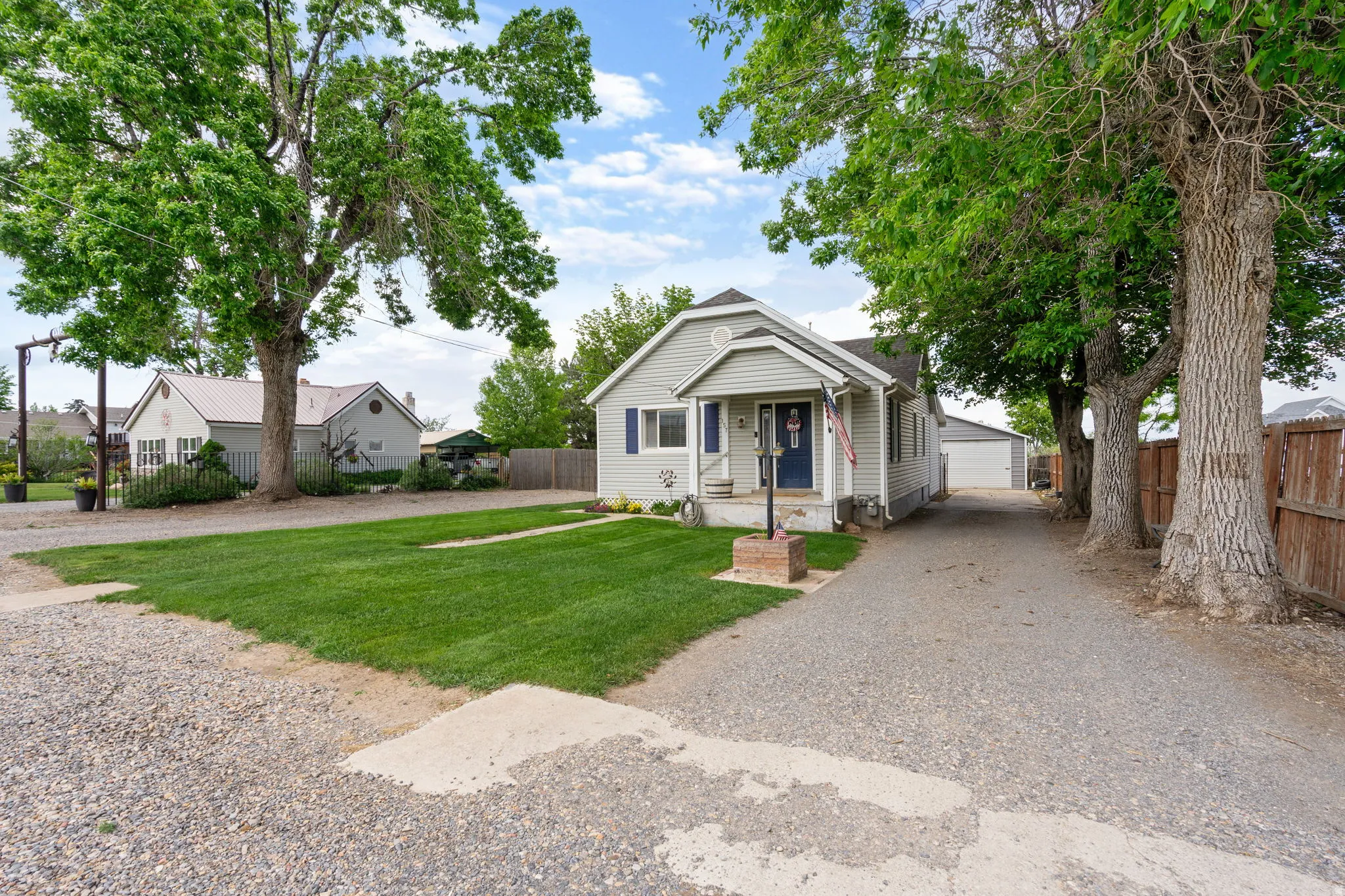 Light gray siding exterior with a dark blue front door and white trim