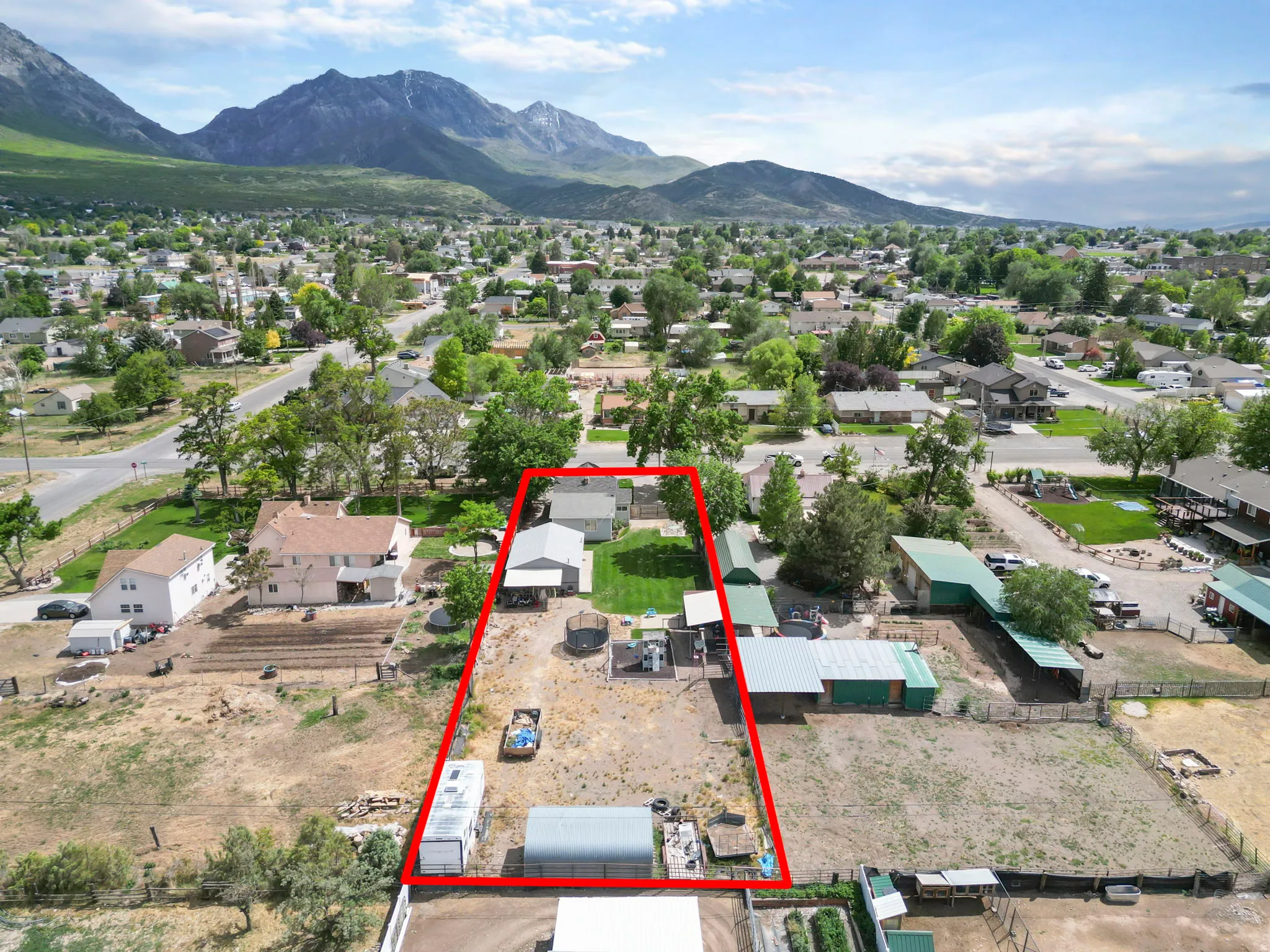 Expansive property featuring a single-story residence, multiple outbuildings, and a large open lot