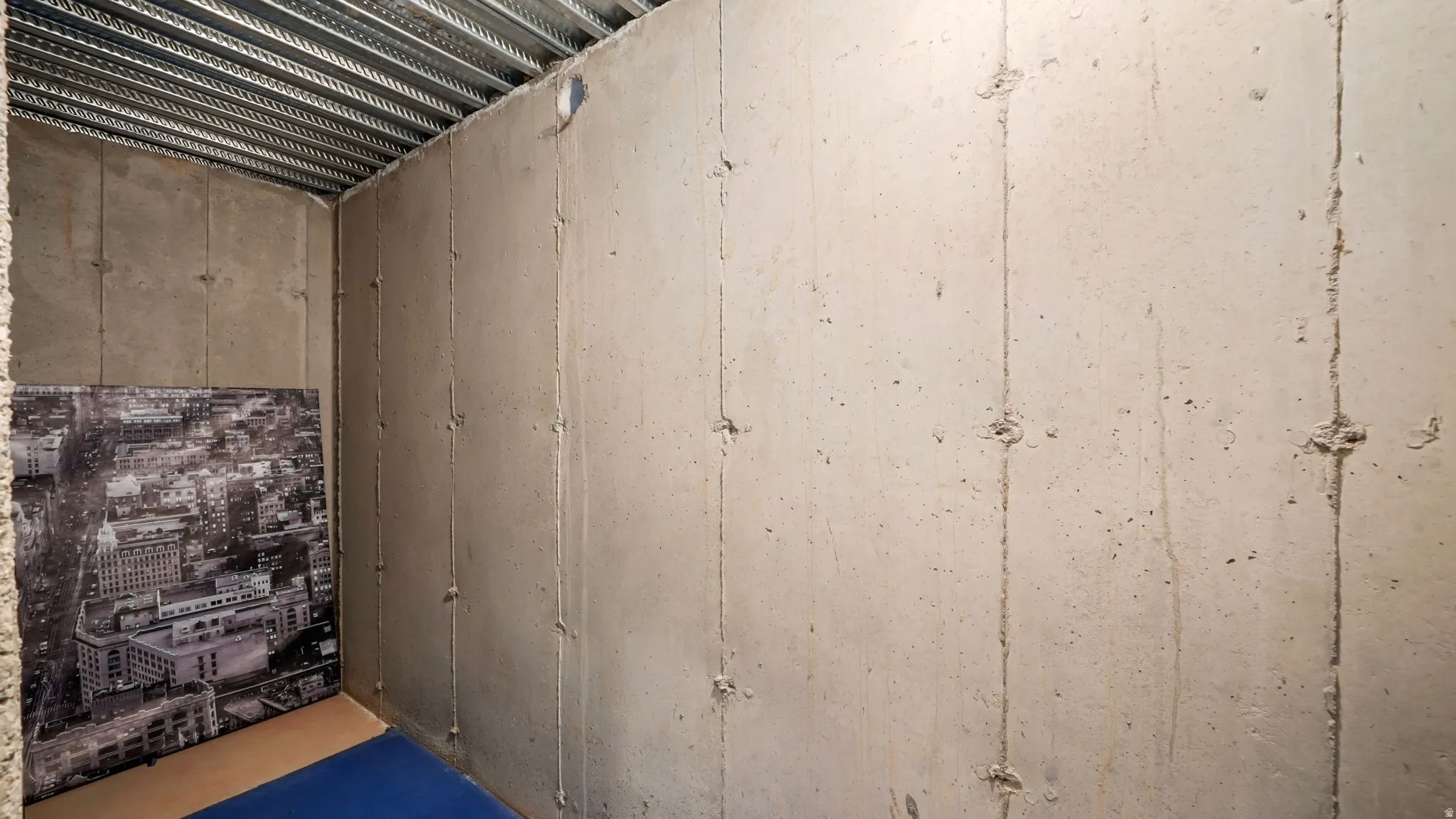 Concrete walls with visible formwork patterns and a metal deck ceiling structure