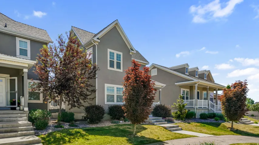 Exterior stucco finish with white trim windows and a covered front porch featuring white railings