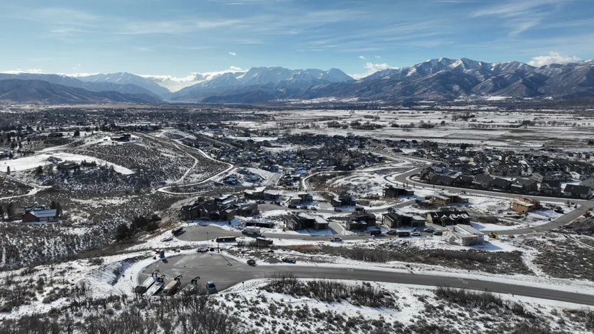 Snowy aerial view featuring a mountain view and a residential view