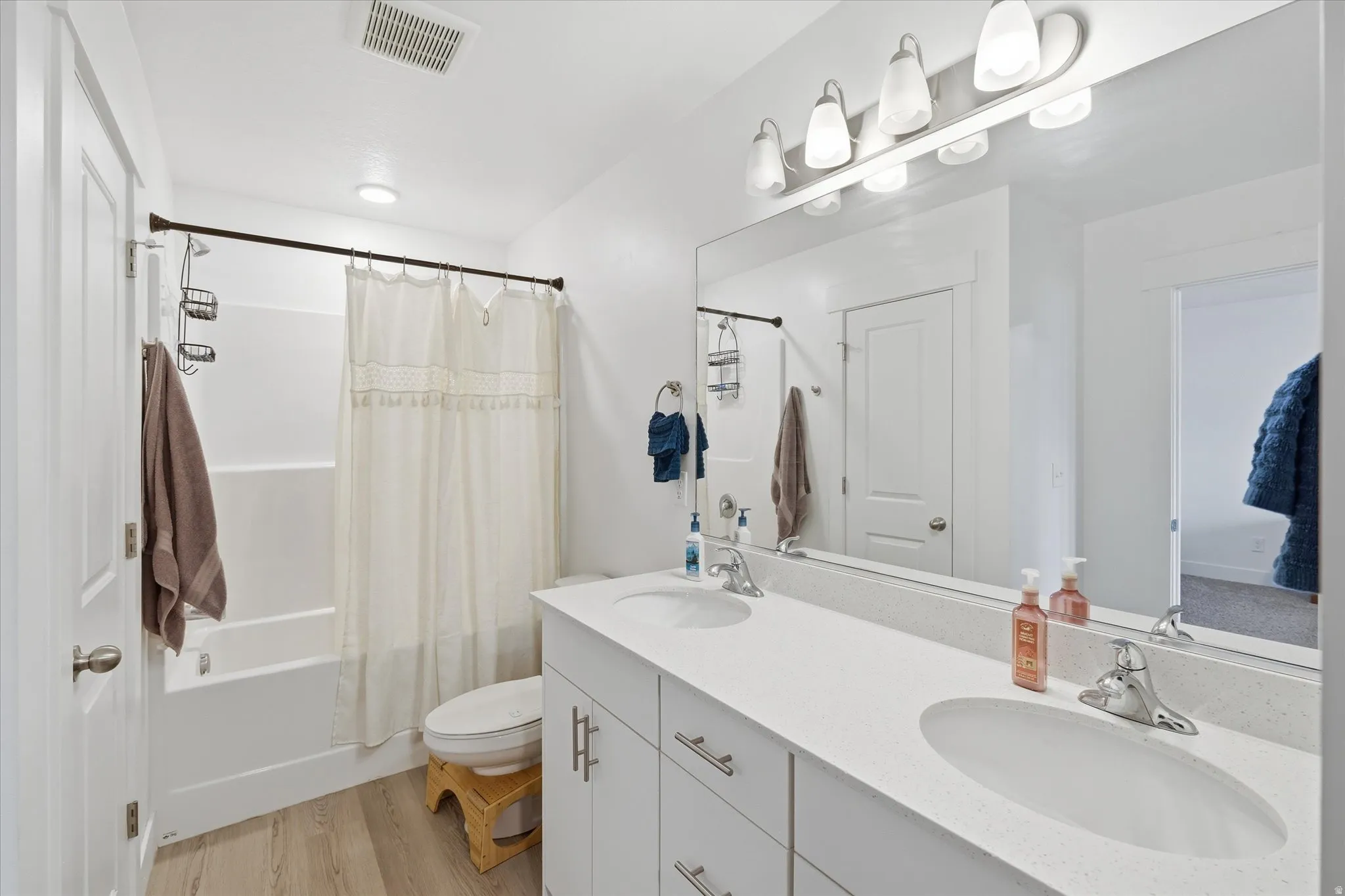 Bathroom featuring a dual vanity with undermount sinks, a white countertop, and chrome fixtures