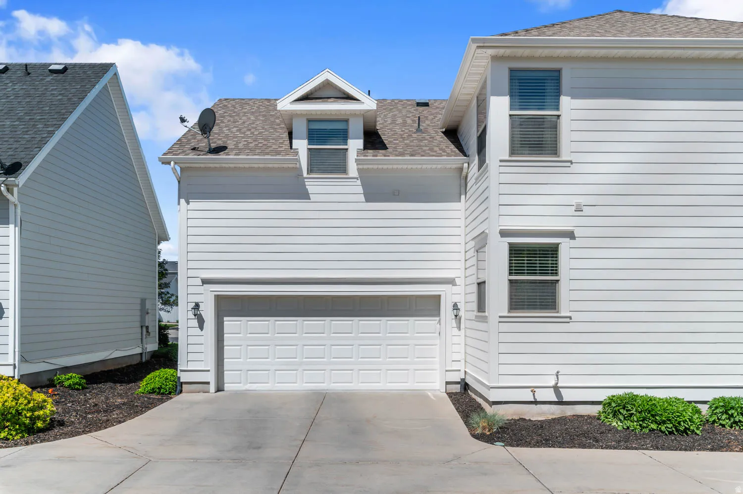 White horizontal siding exterior with an attached two-car garage