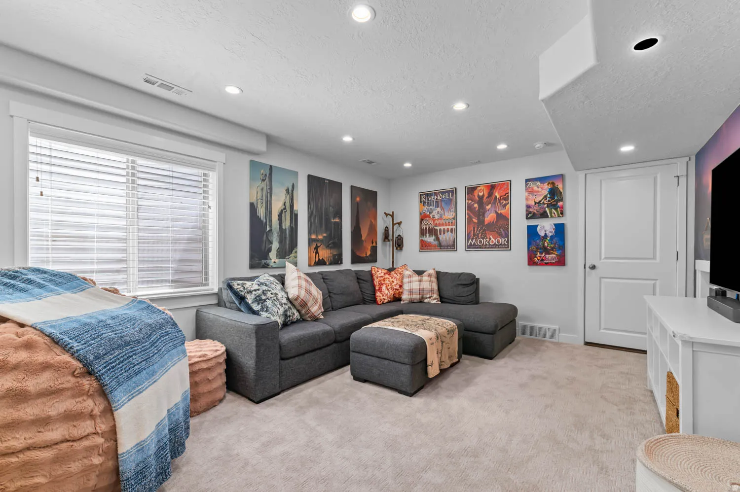 Carpeted room featuring recessed lighting, a window with blinds, white trim, and a white two-panel door