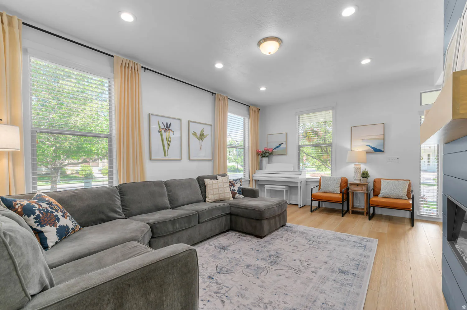 Bright living area with wood-finish flooring, recessed lighting, and ample natural light from multiple windows