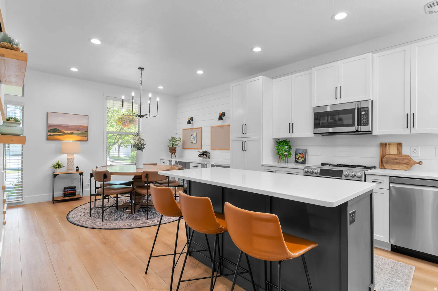 Open-concept kitchen and dining area featuring light wood-finish flooring
