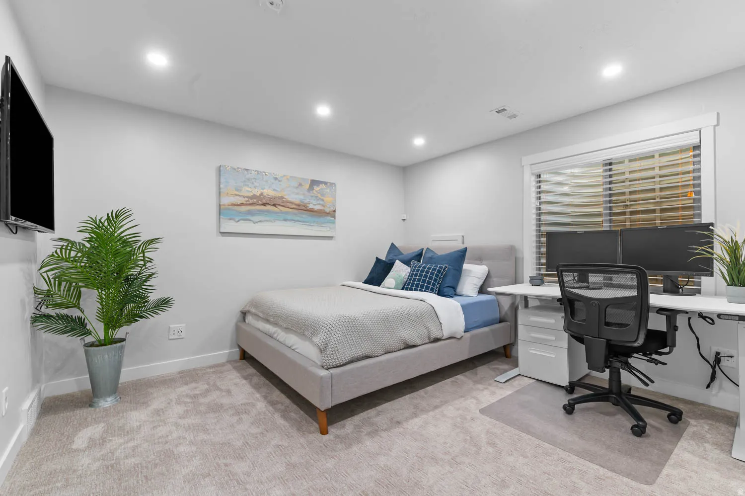 Carpeted room featuring recessed lighting, a modern window with horizontal blinds, and a built-in wall-mounted television