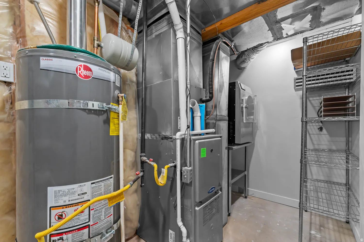 Dedicated utility space featuring a Rheem water heater, furnace, and a wall-mounted ventilation unit