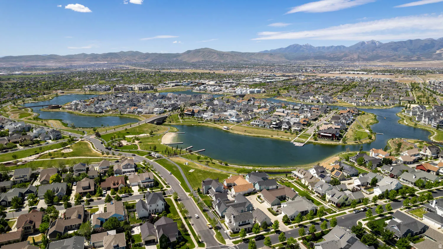Aerial perspective showcasing a residential community with multiple lakes and surrounding green spaces