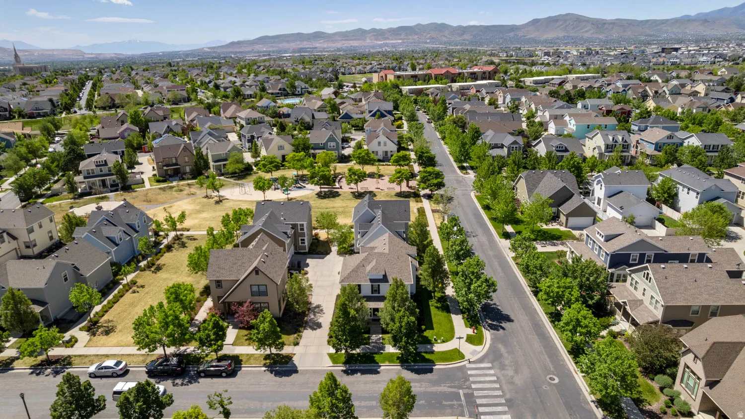 Aerial depiction of a residential neighborhood featuring paved streets, mature trees, and detached single-family residences
