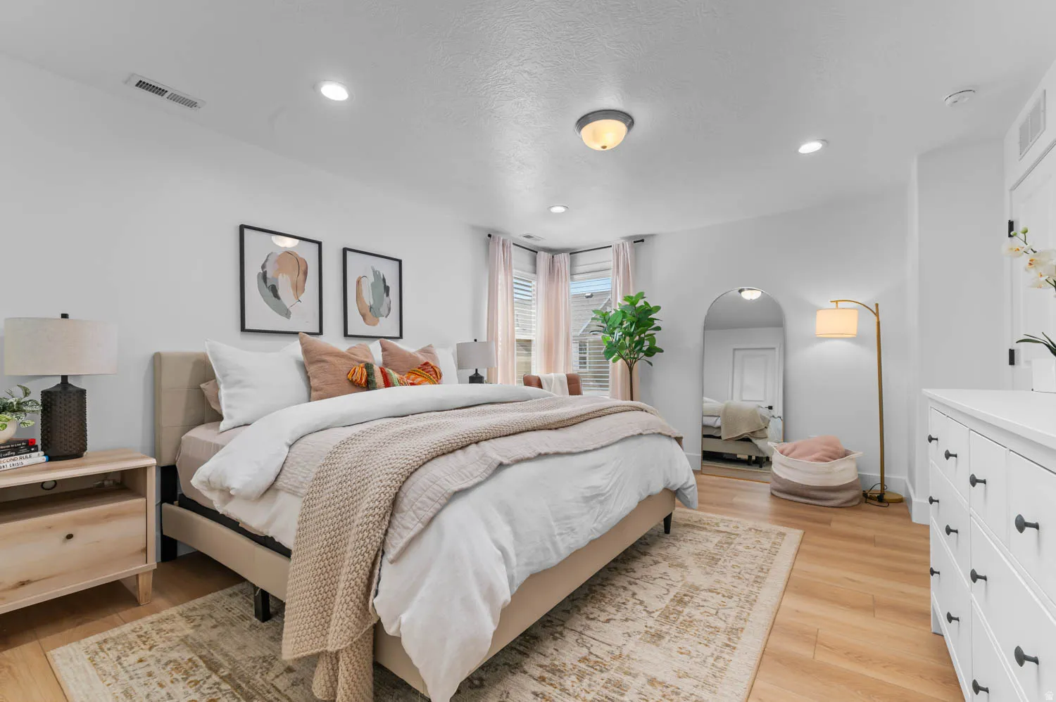 Bright room featuring light wood-finish flooring, recessed lighting, and a neutral color palette