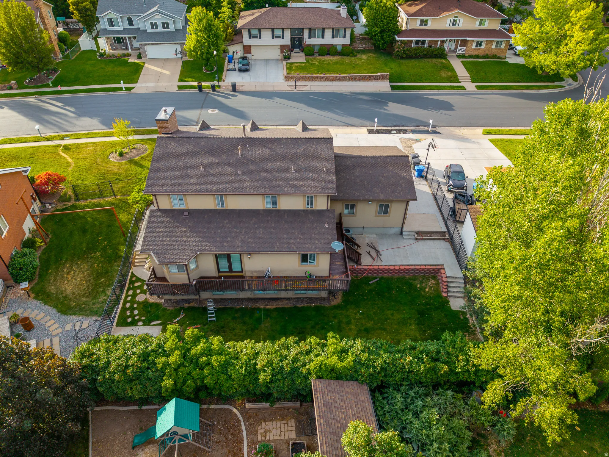 Two-story residence with a brown shingle roof and beige siding