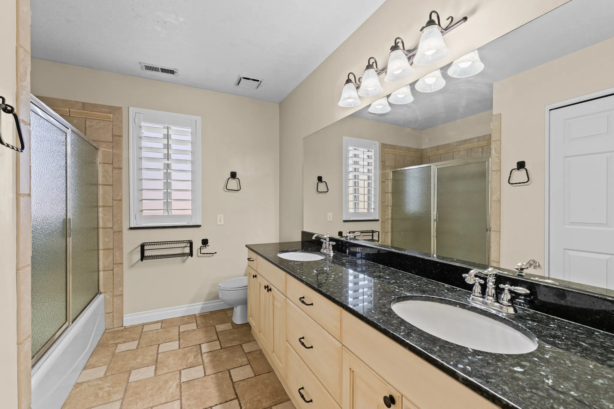 Dual vanity with dark stone countertop and integrated sinks