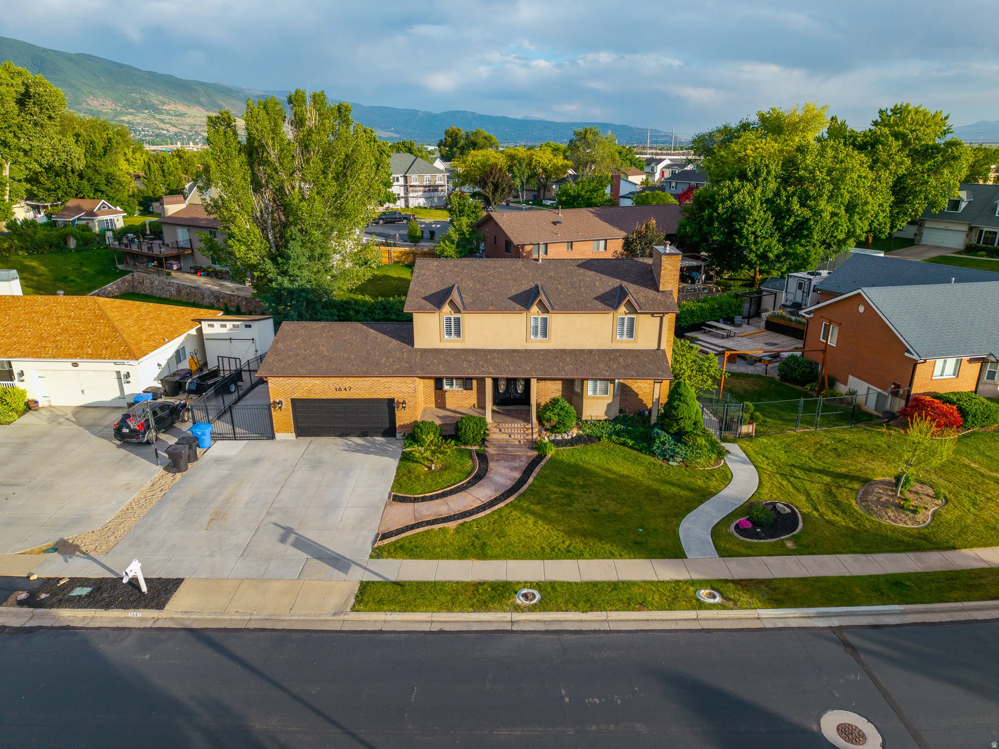 Two-story residence featuring a brick and stucco exterior, dormer windows, and a covered entry porch