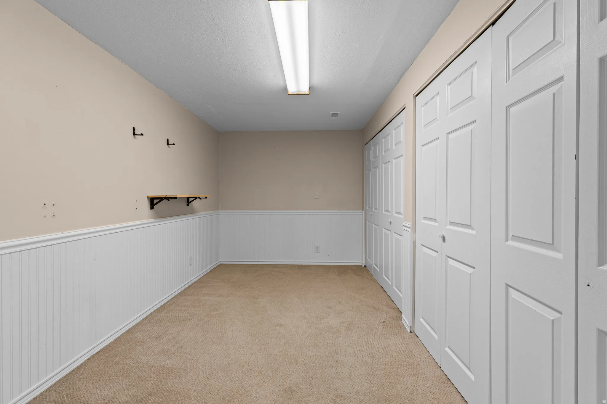 Neutral-toned carpet flooring complementing a full wall of bi-fold closet doors