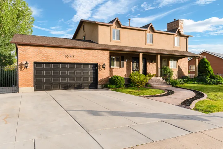 Brick and stucco exterior with a covered front porch featuring columns