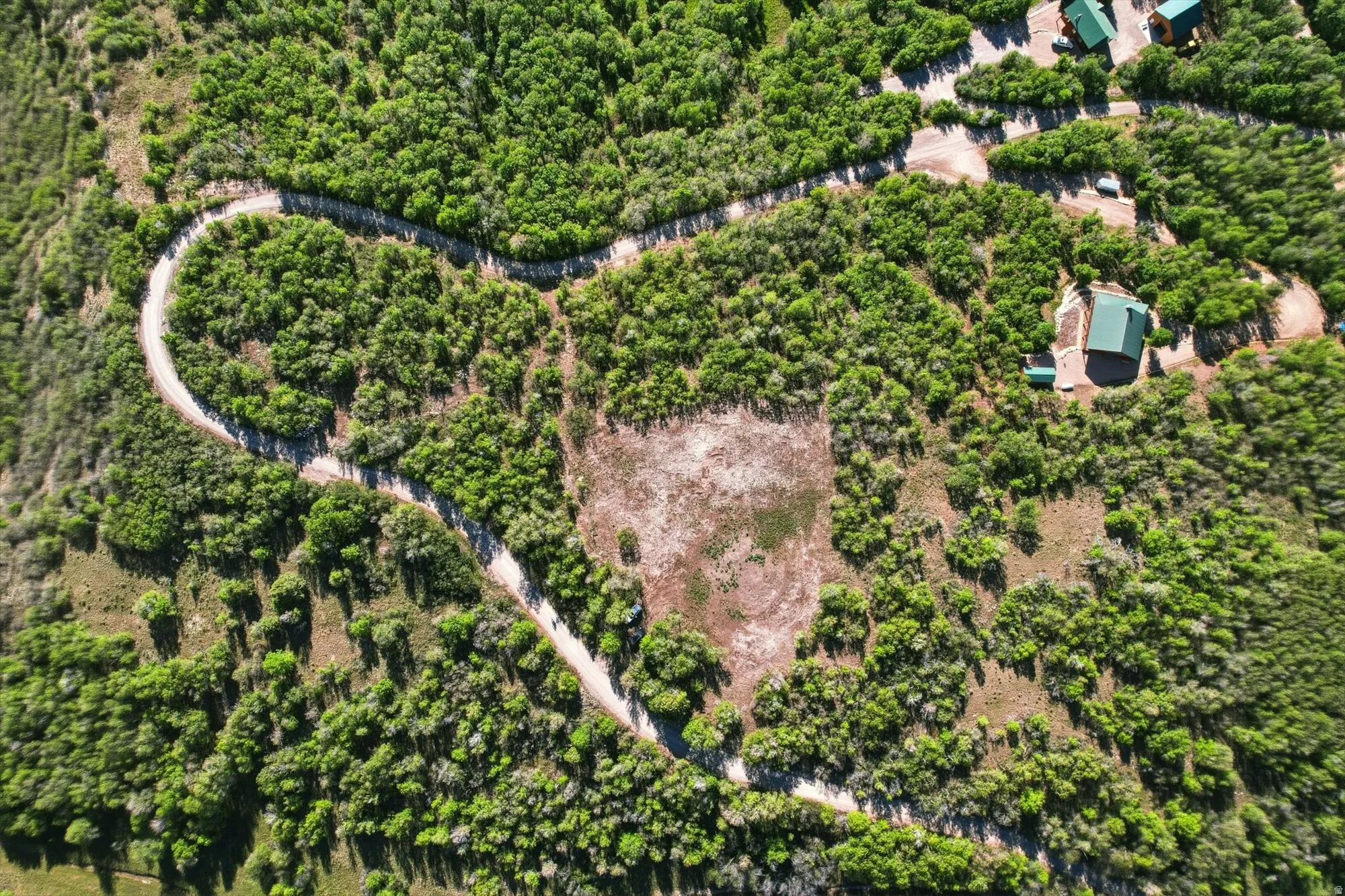 A winding access road, and a substantial cleared building pad