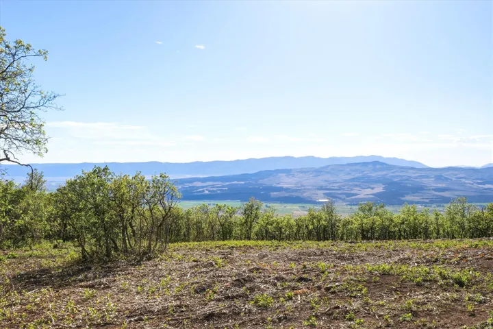 Expansive natural landscape featuring distant mountain ranges and a clear sky