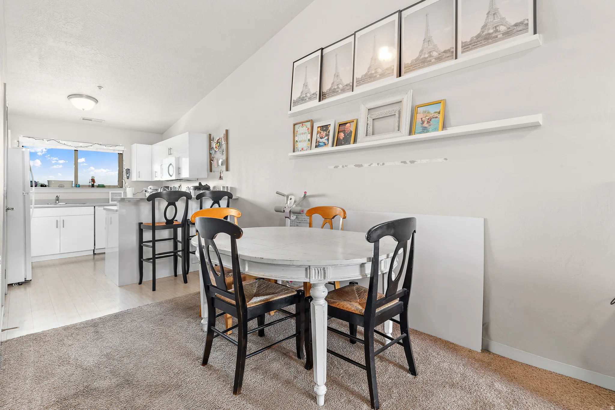 Open concept living area featuring a kitchen with white cabinetry and an eat-at counter