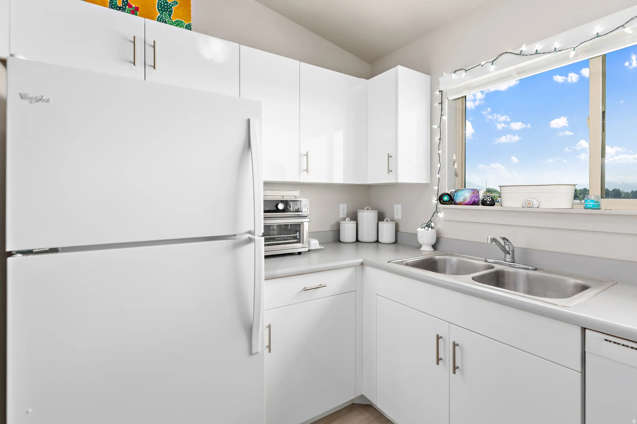 Bright kitchen featuring white cabinetry and light-toned countertops