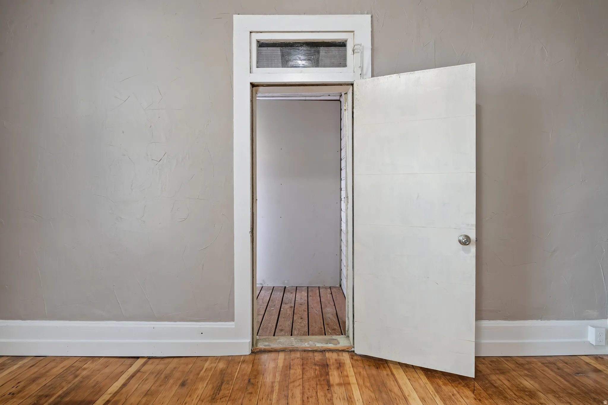Hardwood flooring extends throughout this space, complemented by neutral wall tones