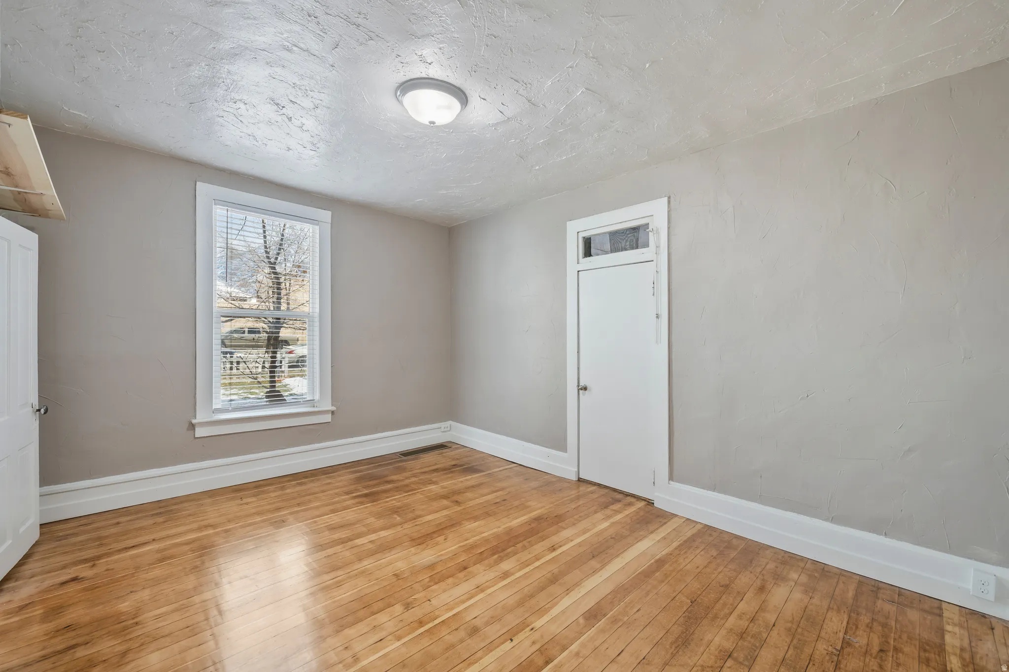 Hardwood flooring and light gray walls create a bright interior