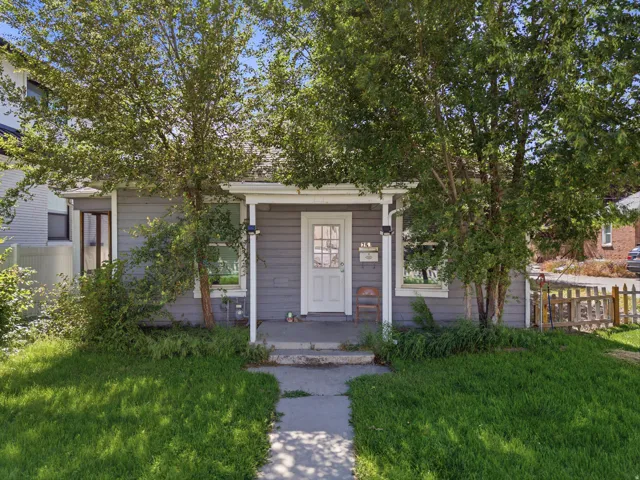 Gray exterior siding with white trim, featuring a covered front porch and a white entry door