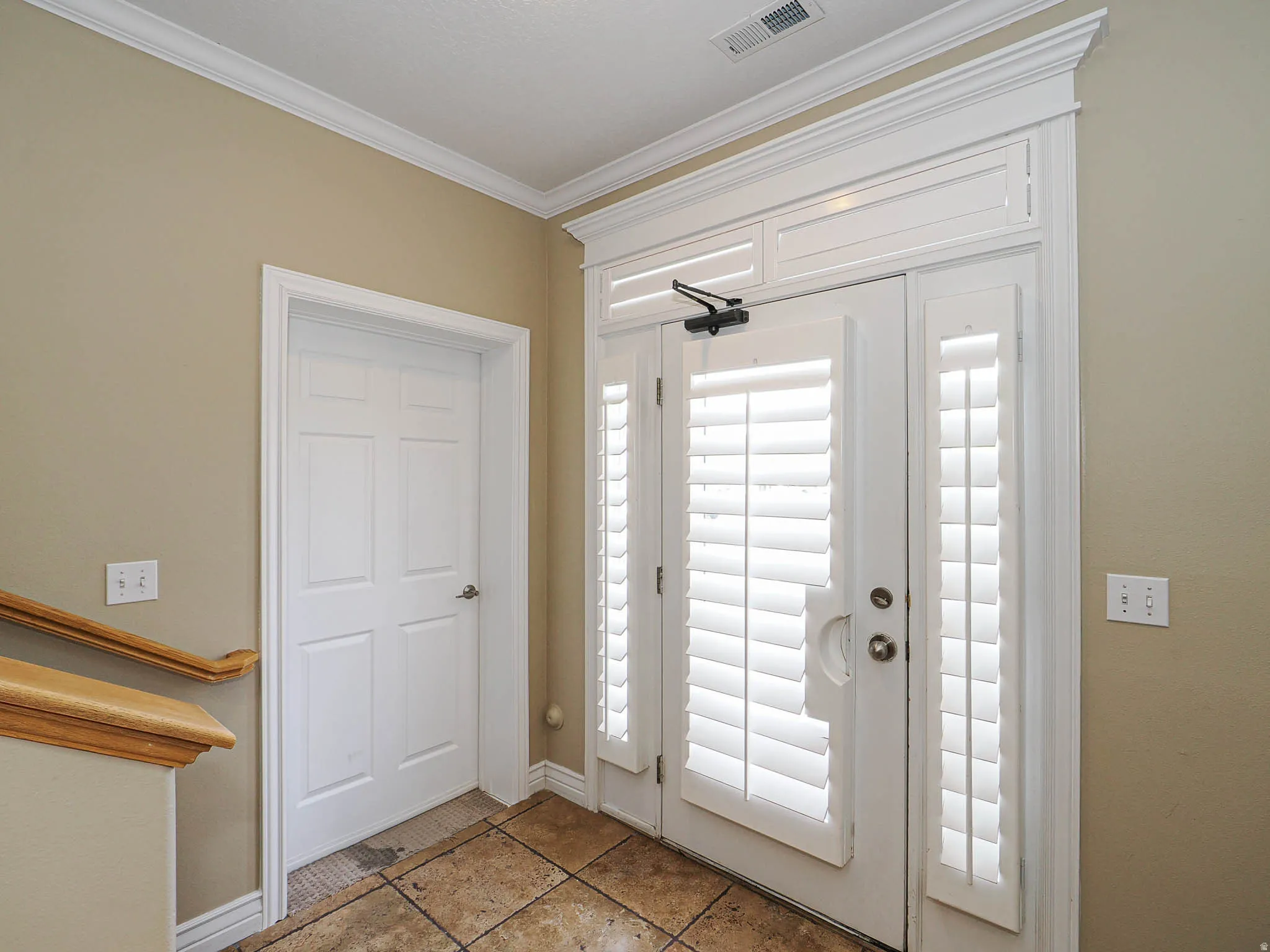 Entrance foyer with crown molding and baseboards