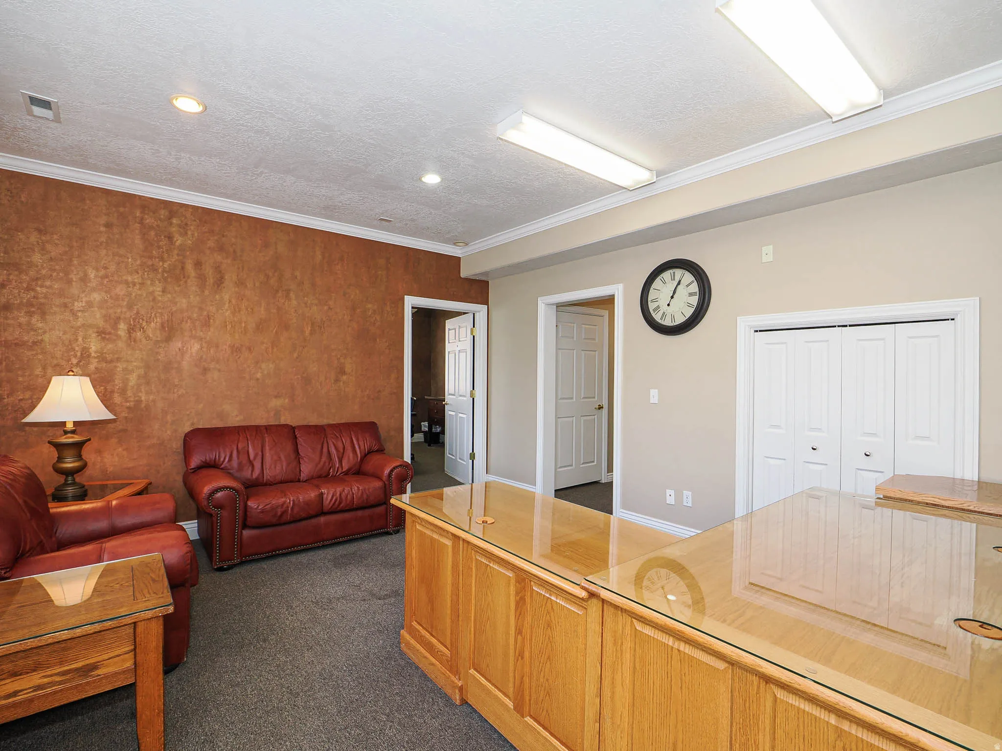 Living area with ornamental molding, dark carpet, and a textured ceiling