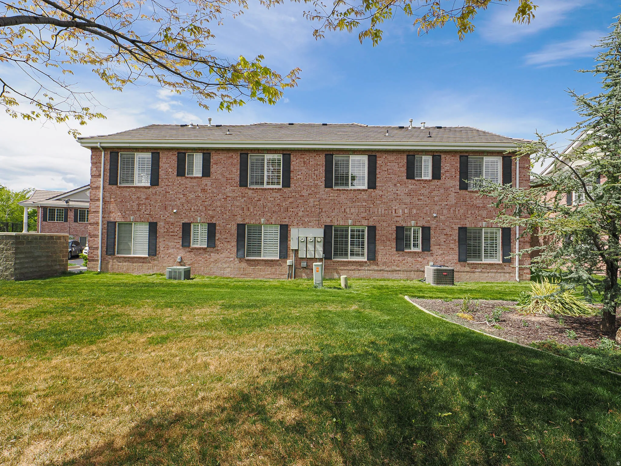 Rear view of house with a lawn and brick siding