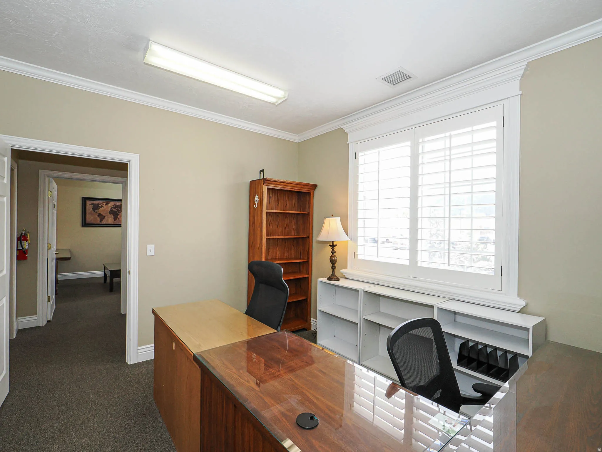 Home office with crown molding and dark carpet