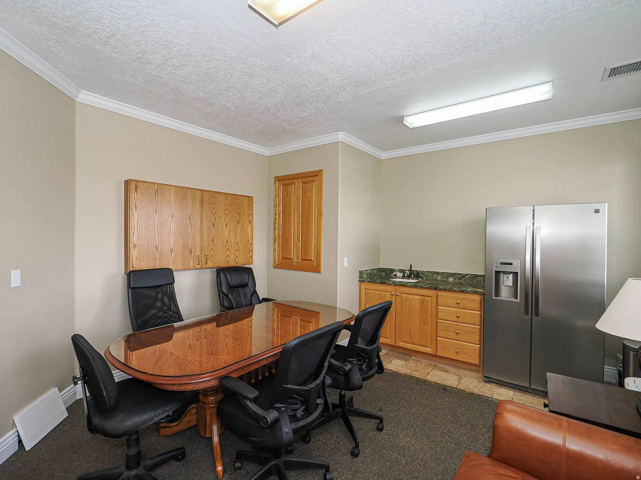 Office with stone tile flooring, crown molding, and a textured ceiling