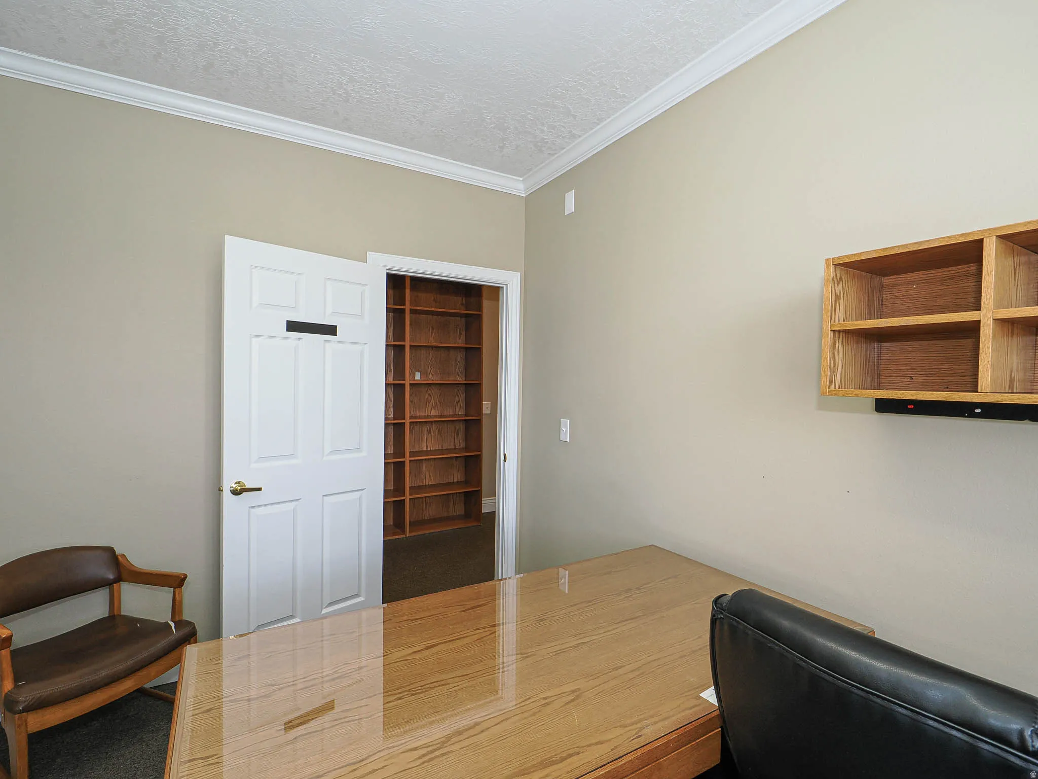 Office space with ornamental molding and a textured ceiling