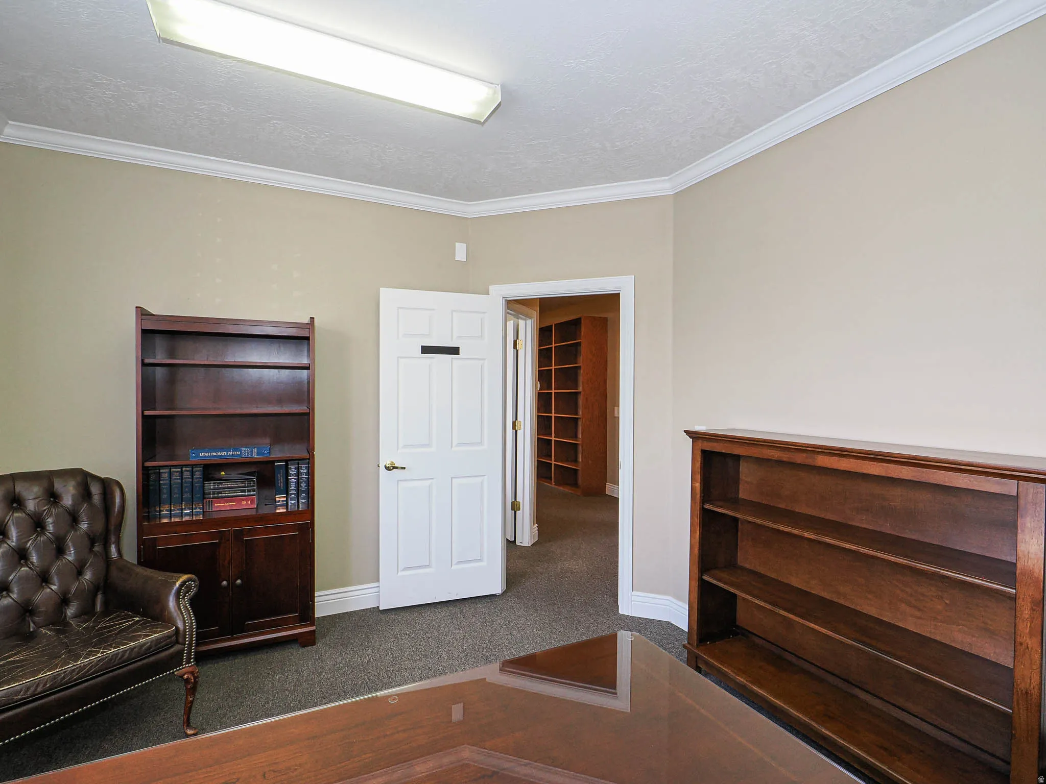 Sitting room featuring crown molding, dark carpet, and a textured ceiling