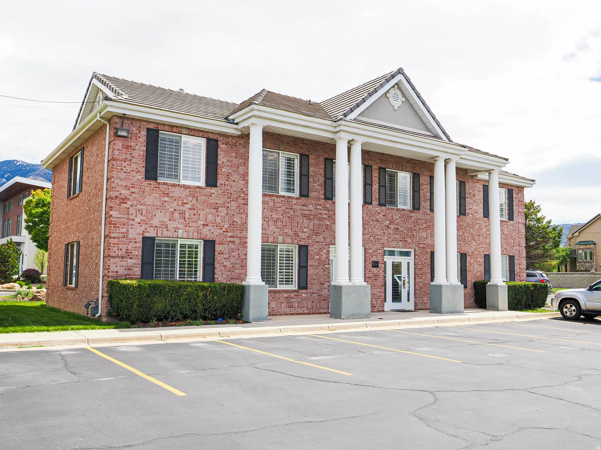 View of front facade featuring brick siding and uncovered parking