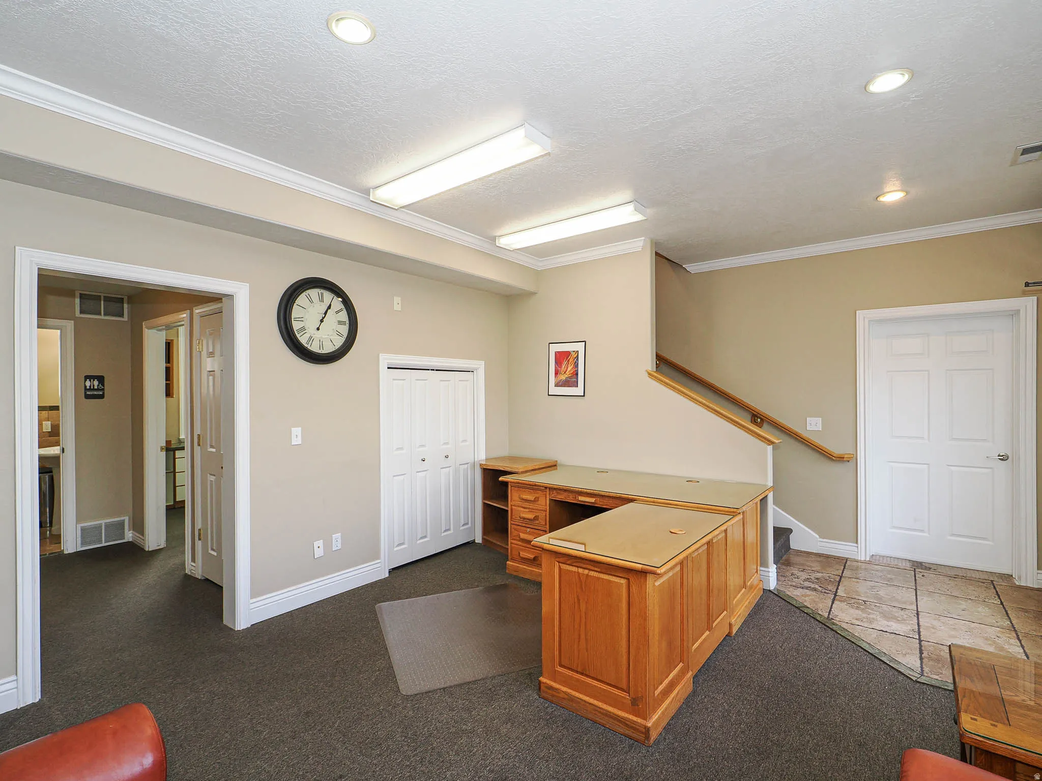 Office with ornamental molding, dark carpet, and a textured ceiling
