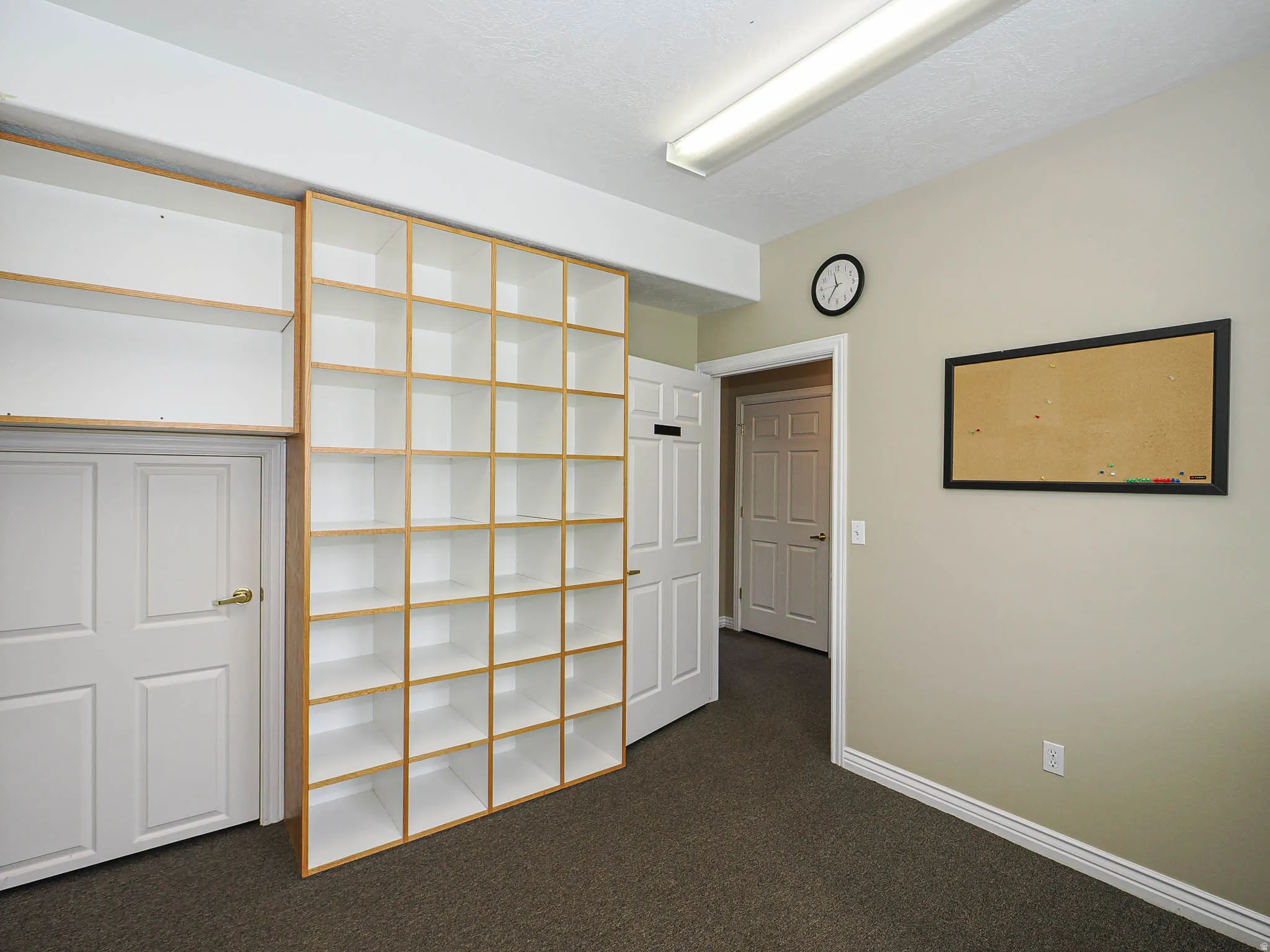 Basement featuring dark carpet and baseboards
