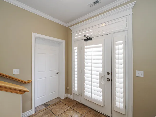 Entrance foyer with crown molding and baseboards