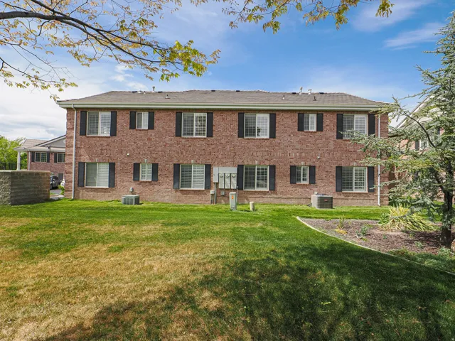 Rear view of house with a lawn and brick siding