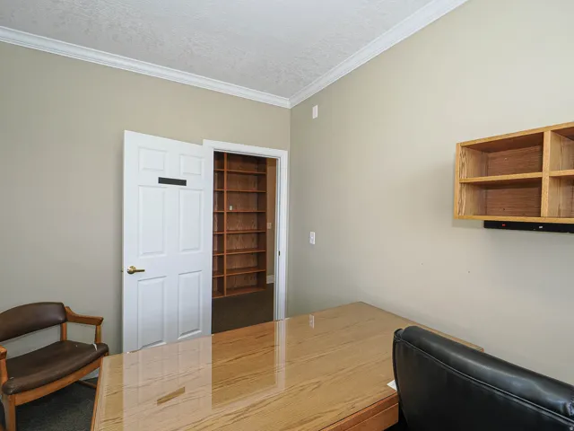 Office space with ornamental molding and a textured ceiling