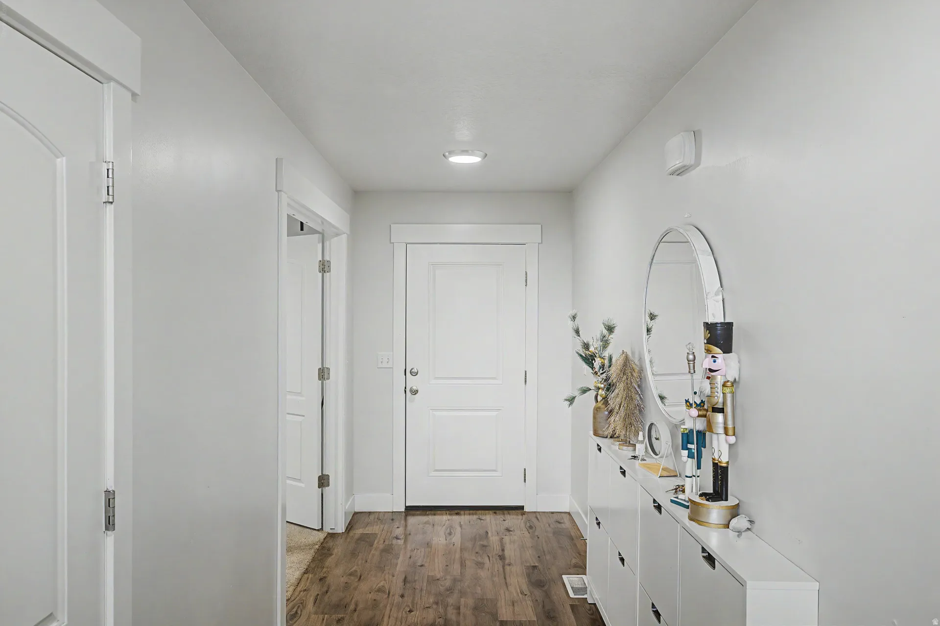 Entryway featuring wood-finish flooring, crisp white walls, and a recessed ceiling light