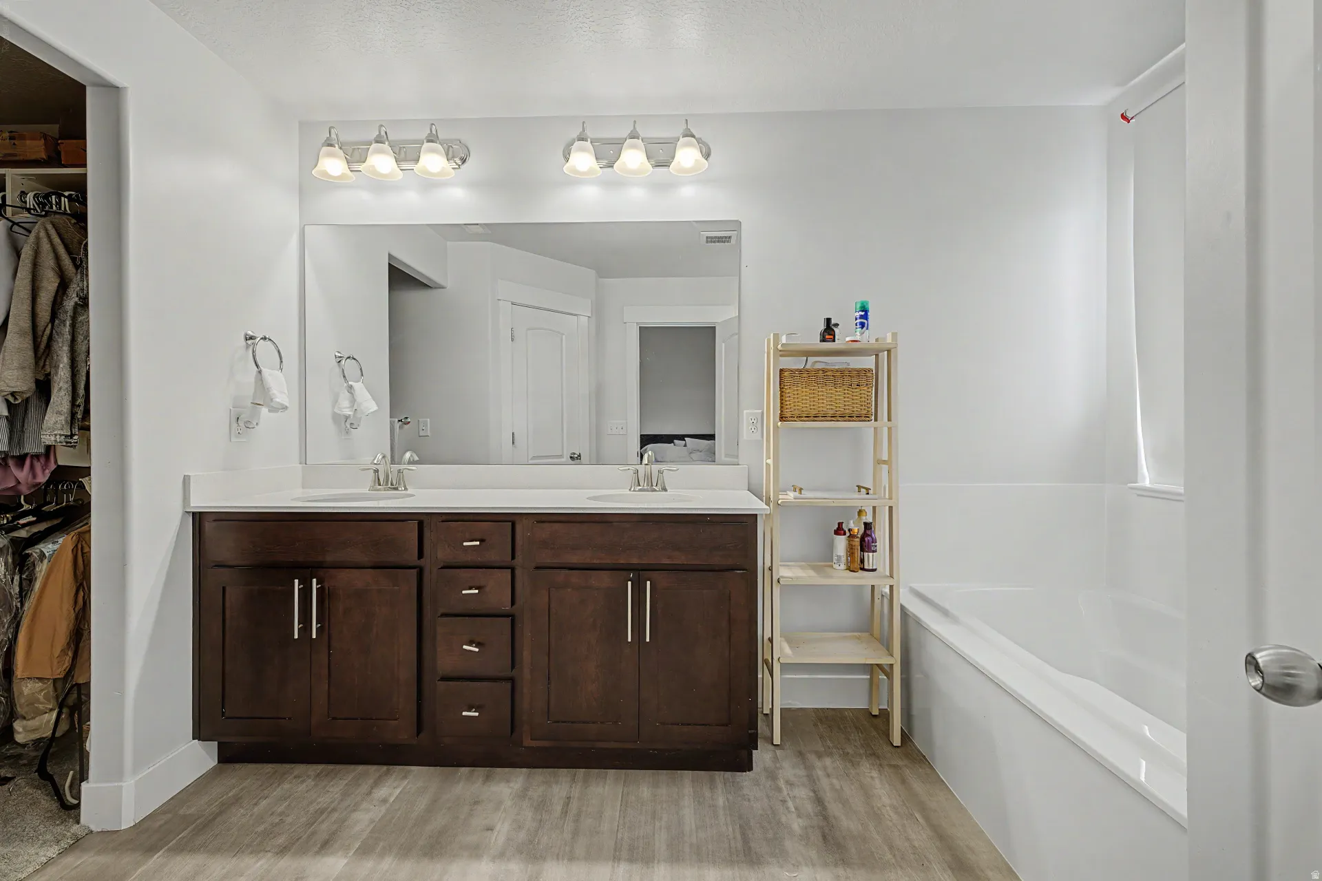 Bathroom featuring a dual vanity with dark wood cabinetry and a white countertop
