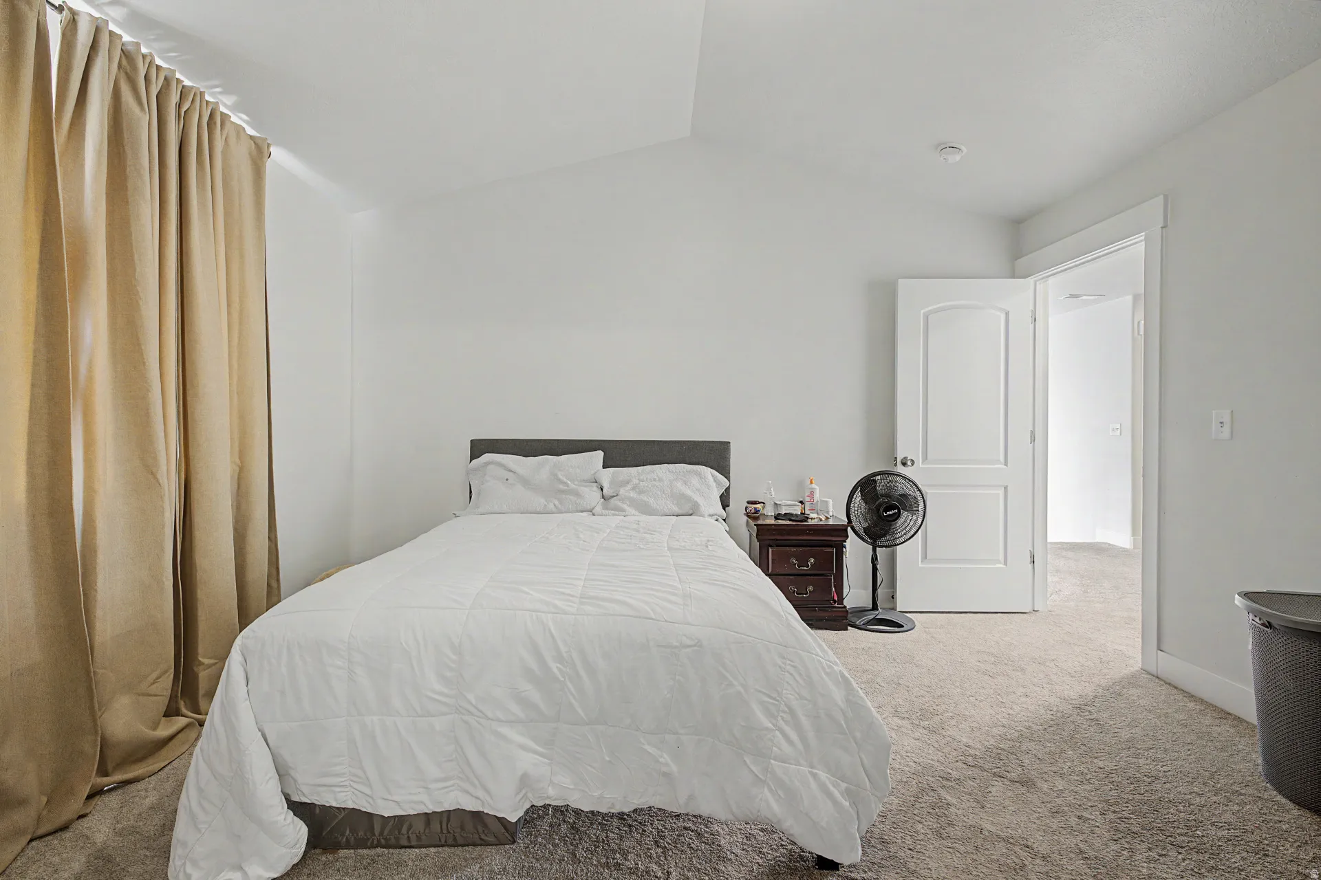 Carpeted bedroom with vaulted ceiling and light-toned walls