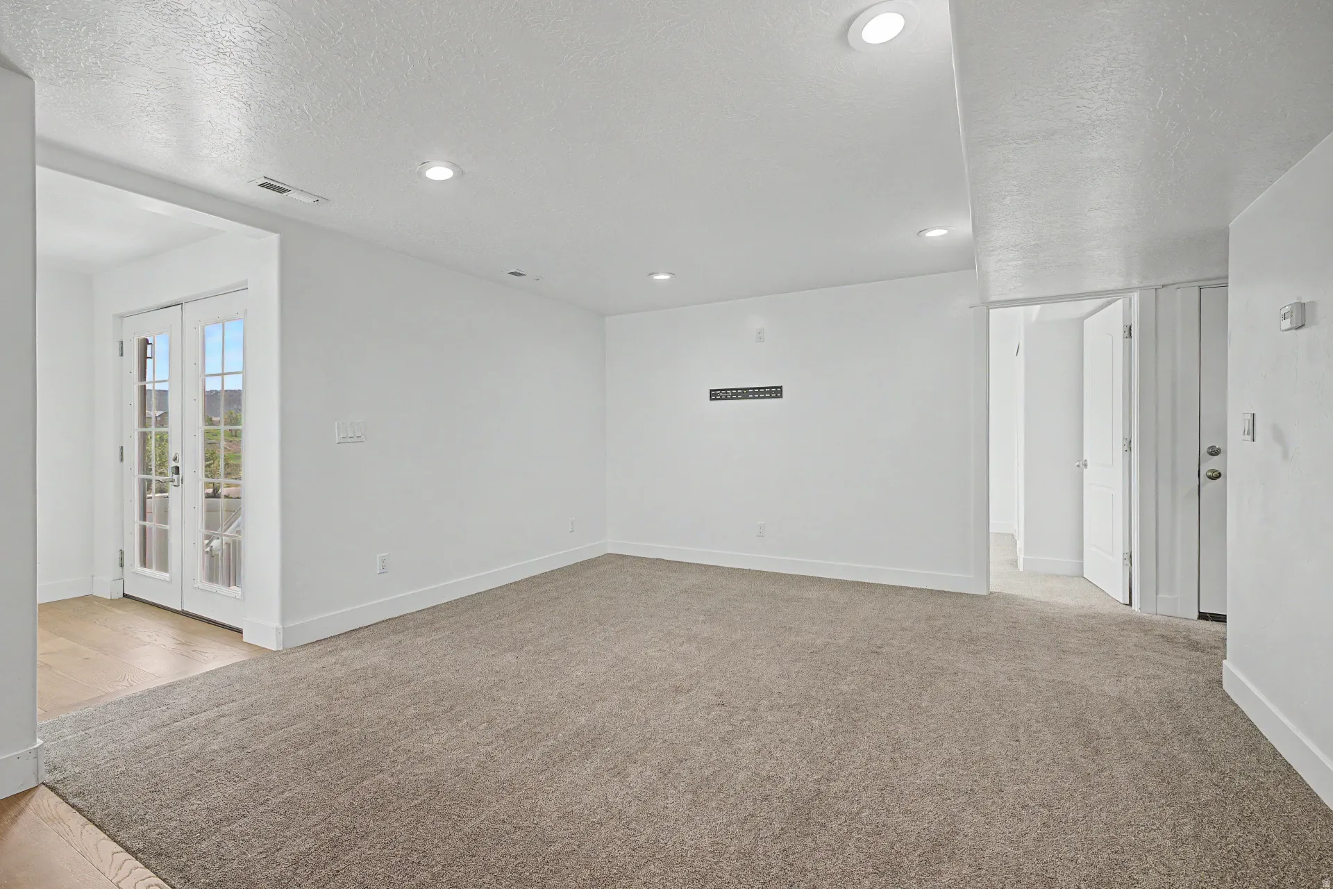 Spacious room featuring neutral carpeting and recessed lighting