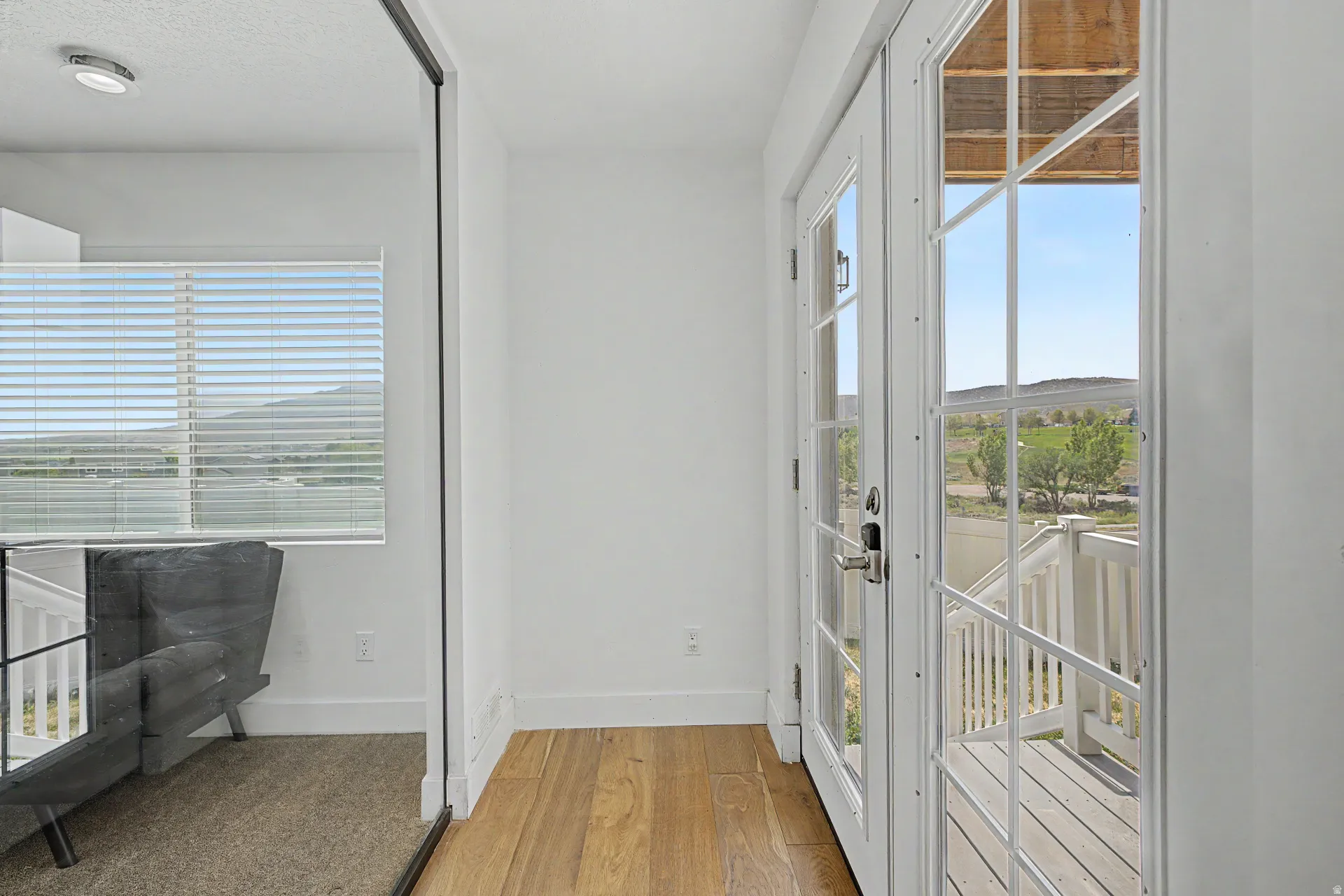 Basement entry French doors with white grilles leading to an exterior balcony