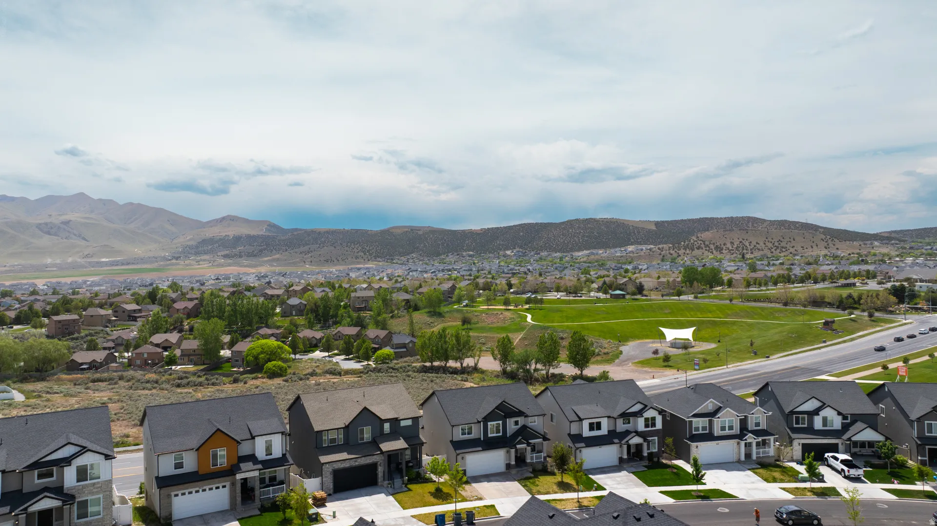 Neighborhood setting featuring varied architectural styles, paved roadways, and extensive green spaces