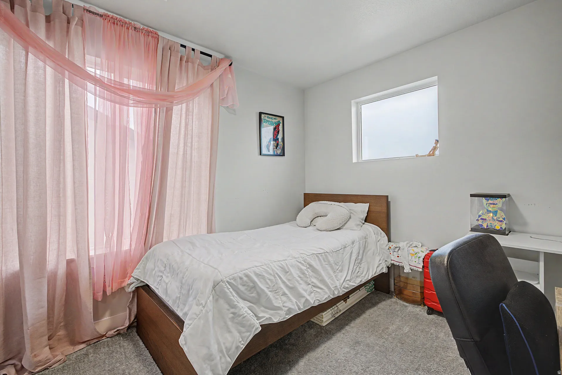 Bright room featuring a large window with sheer curtains, a smaller transom-style window, light gray carpet flooring, and white painted walls