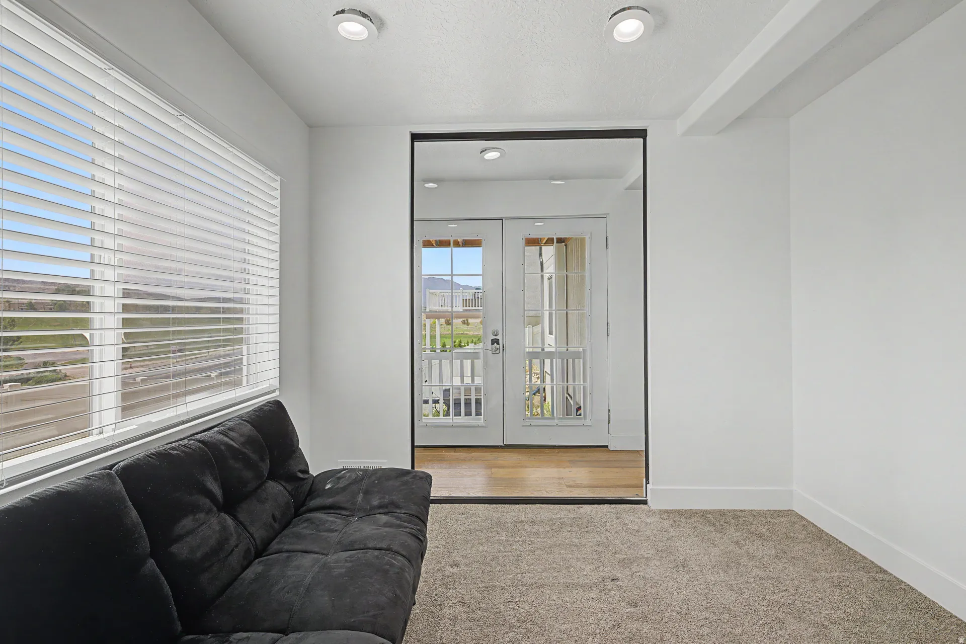 Basement bedroom Carpeted interior space featuring recessed lighting and a large window with horizontal blinds