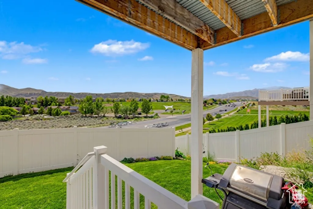 Ai enhanced backyard  showing rear outdoor living space featuring a covered patio, white vinyl fencing, and a grassy lawn
