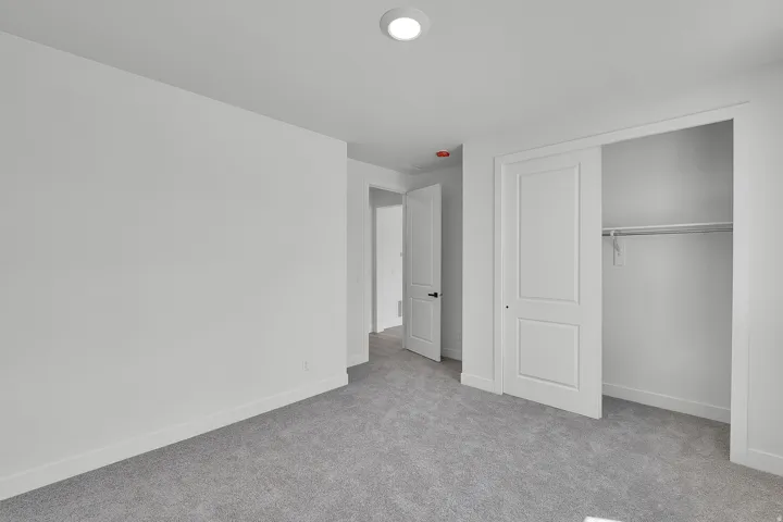 Carpeted room with recessed lighting, white walls, and white trim